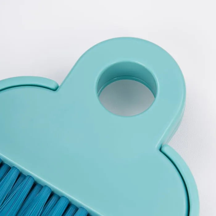 Close-up of IKEA BÖNSYRSA turquoise desk cleaning brush.