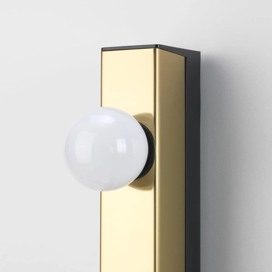 Close-up of IKEA MUSIK brass wall lamp