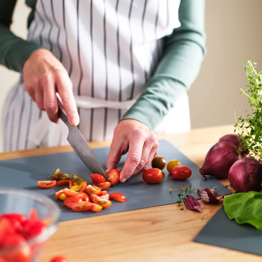 FINFÖRDELA Bendable chopping board, dark green/grey-turquoise, used for cutting vegetables.