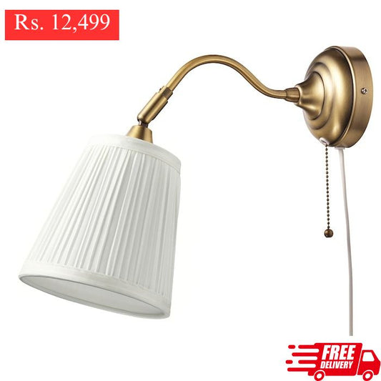 IKEA ARSTID wall lamp in gold color.