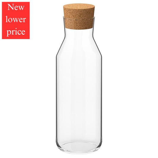 Clear glass carafe with cork lid on a white background