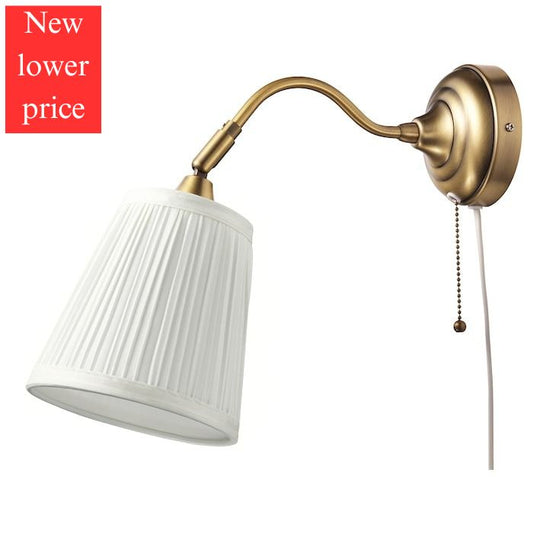 IKEA ARSTID wall lamp in gold color.