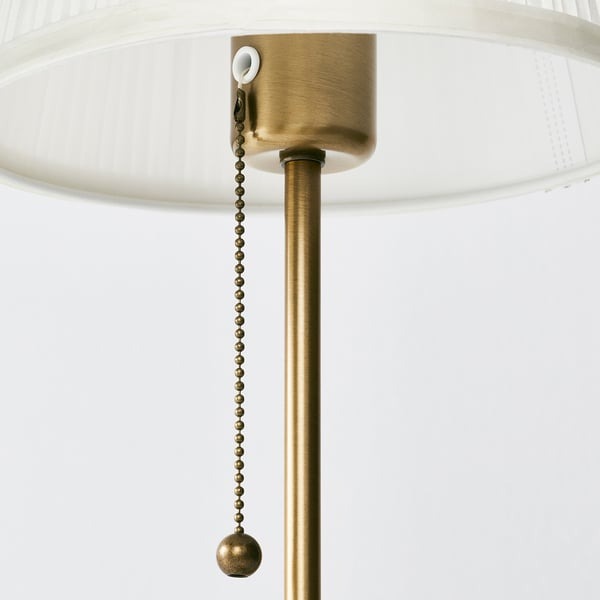 Close-up of IKEA ÅRSTID lamp brass base and white lampshade.