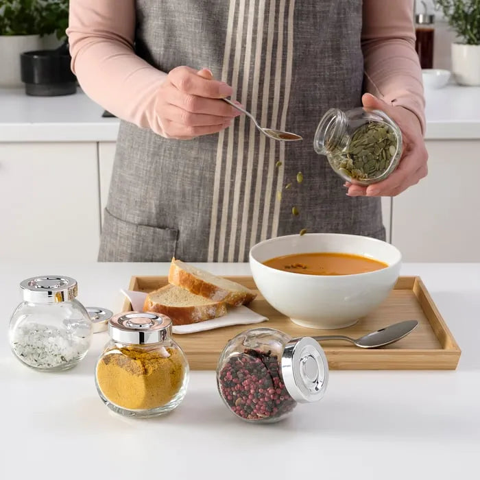 IKEA RAJTAN spice jars on kitchen shelf.