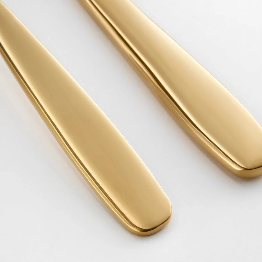 Close-up detail of the brass-colour finish on IKEA TILLAGD serving set